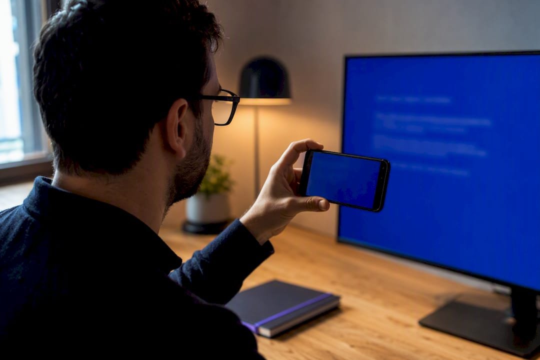Person photographing a blue screen error
