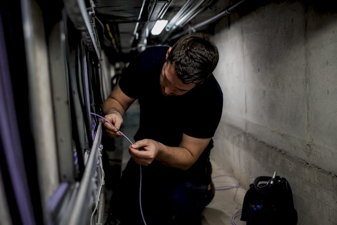 Technician feeding fibre optic cable during an FTTP upgrade