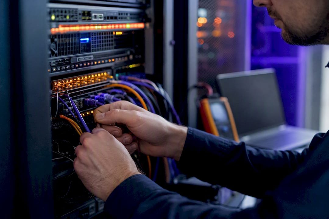 Technician hands checking server cables behind a business website
